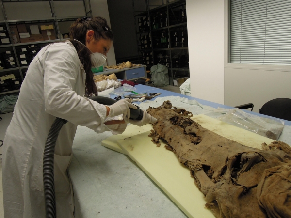 Un'antropologa del laboratorio di Ravenna aspira le polveri da una mummia